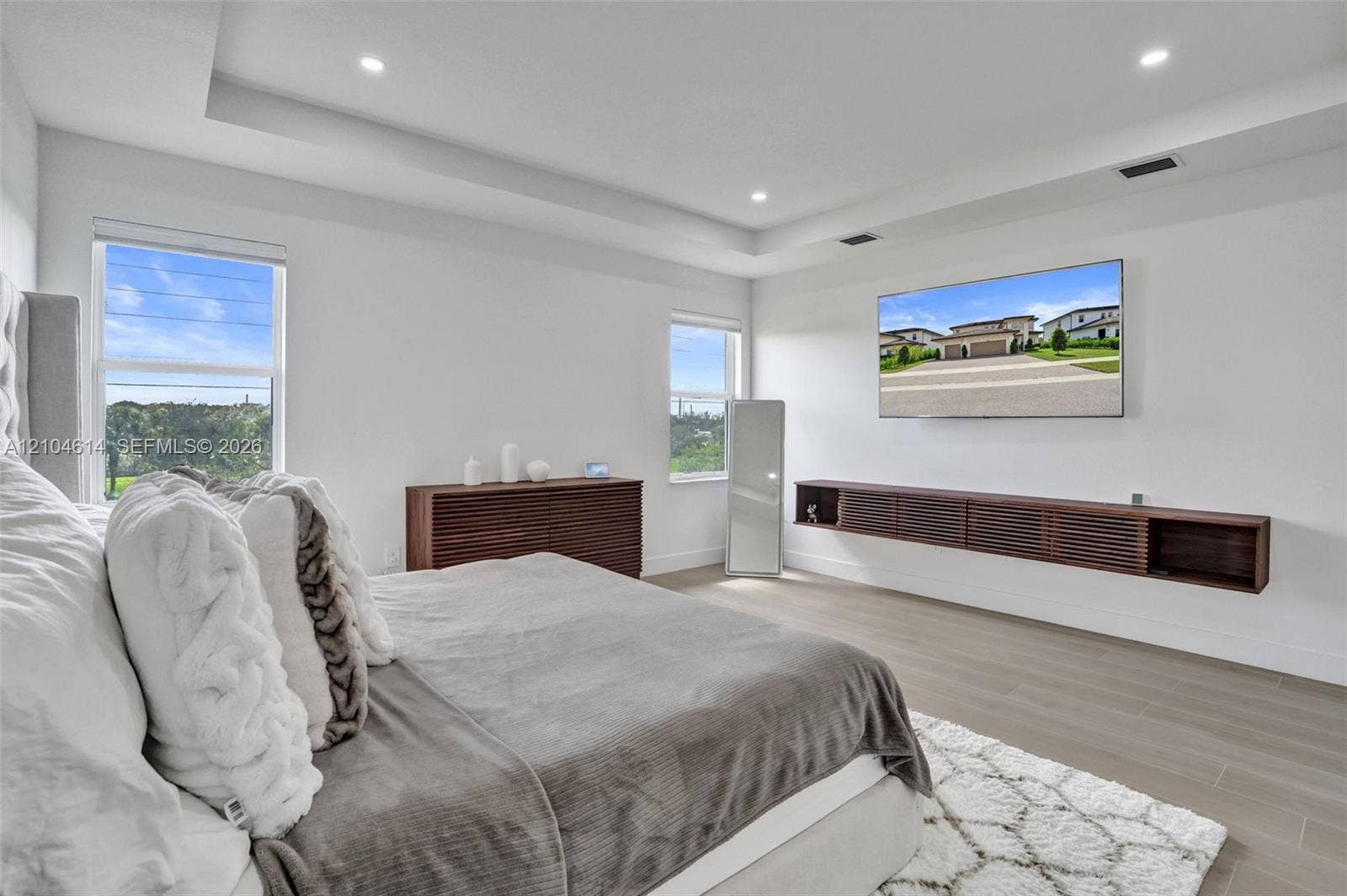 12240 SW 44th Court, Davie, FL 33330 Tray ceiling with recessed lighting, light wood-look flooring, and a built-in floating media cabinet