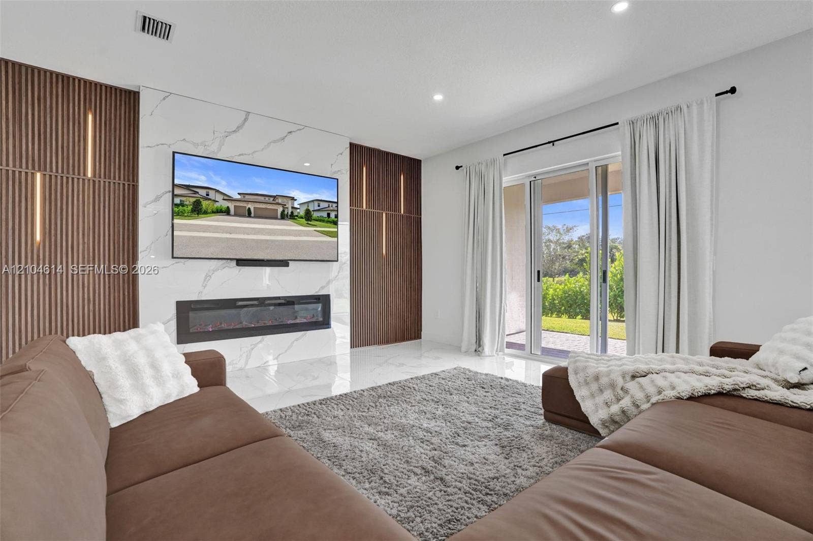 12240 SW 44th Court, Davie, FL 33330 Feature wall with integrated lighting and a linear electric fireplace
