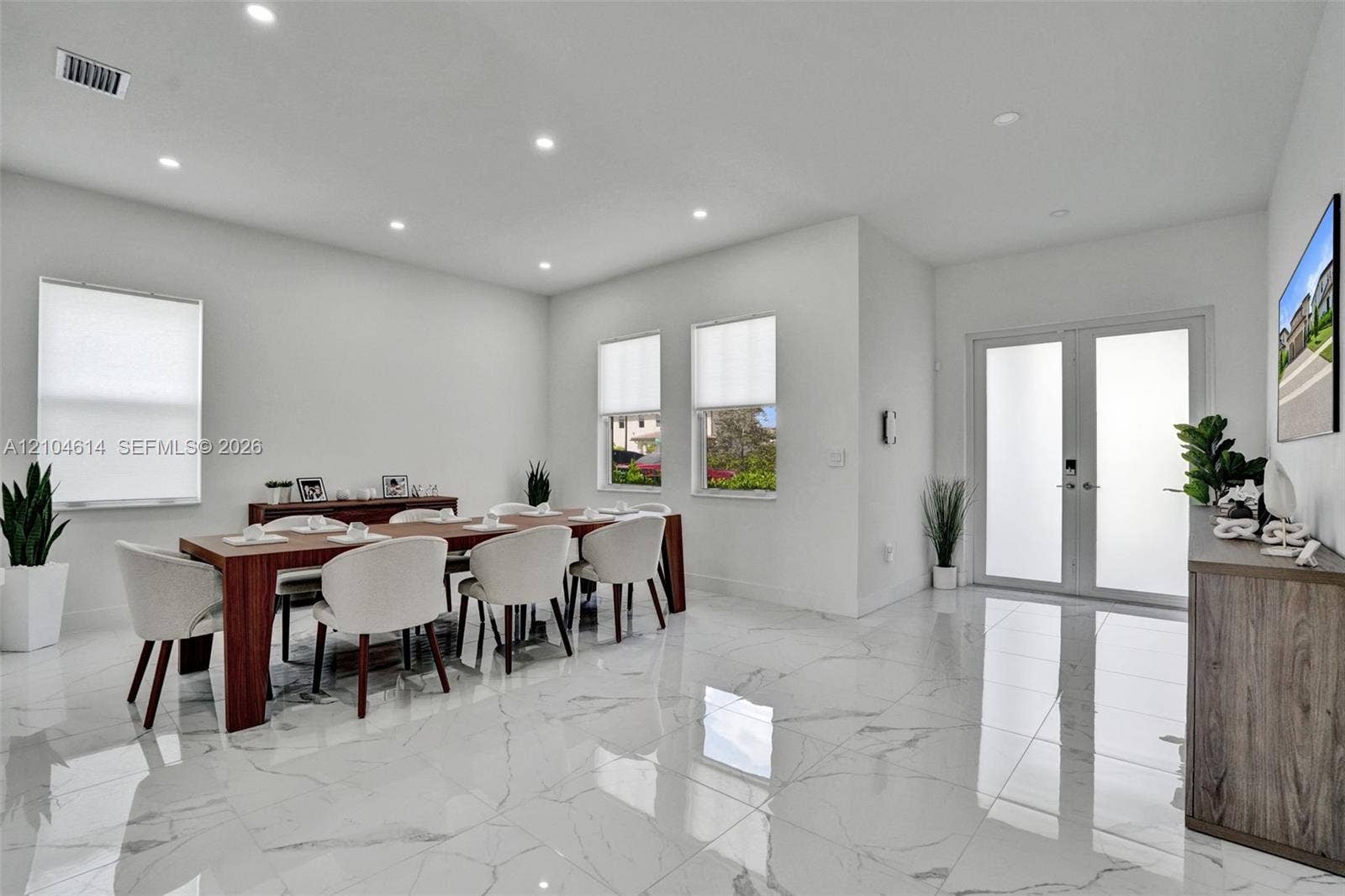 12240 SW 44th Court, Davie, FL 33330 Spacious room featuring large format marble-look tile flooring, recessed lighting, double frosted glass entry doors, and multiple windows