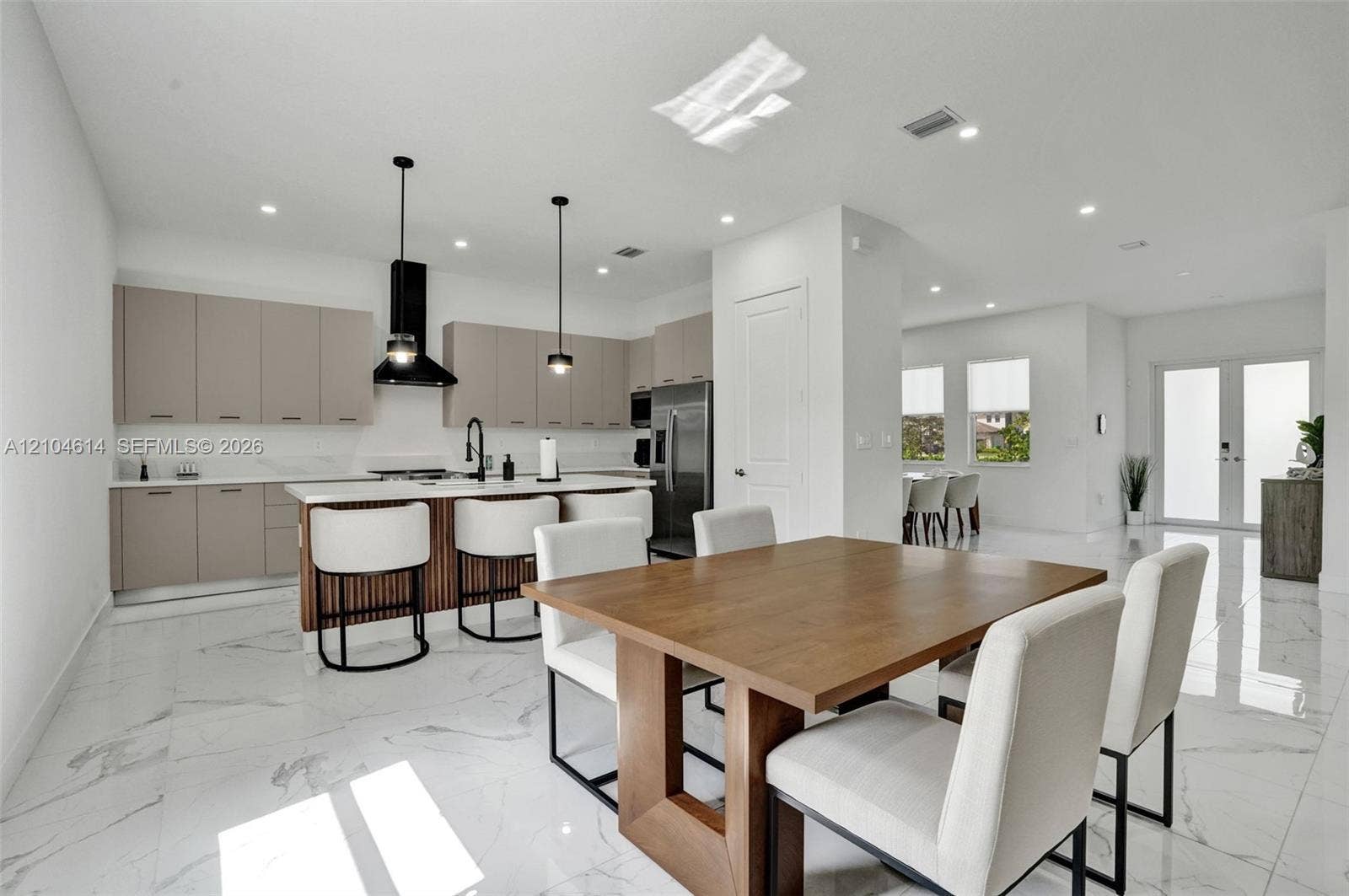 12240 SW 44th Court, Davie, FL 33330 Gourmet kitchen with sleek cabinetry, white countertops, and a central island with bar seating