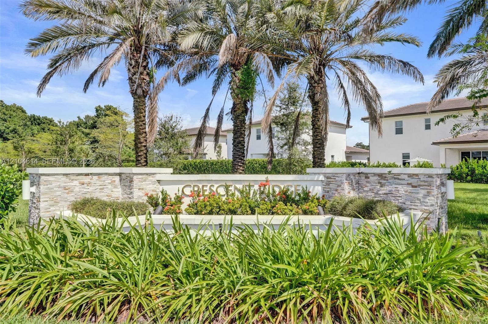 12240 SW 44th Court, Davie, FL 33330 Stone-clad entry monument with integrated landscaping and mature palm trees