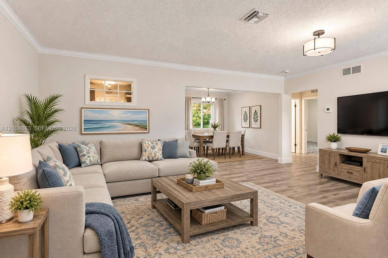 305 NW 111th Street, Miami Shores, FL 33168 Open-concept living space featuring wood-finish flooring, crown molding, neutral wall color, and a semi-flush mount light fixture
