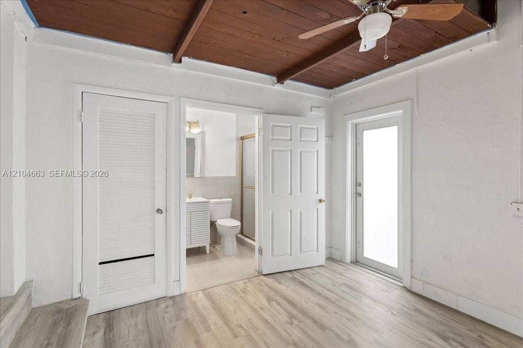 305 NW 111th Street, Miami Shores, FL 33168 Exposed wood-plank ceiling with ceiling fan, light-toned wood-finish flooring, and white paneled doors