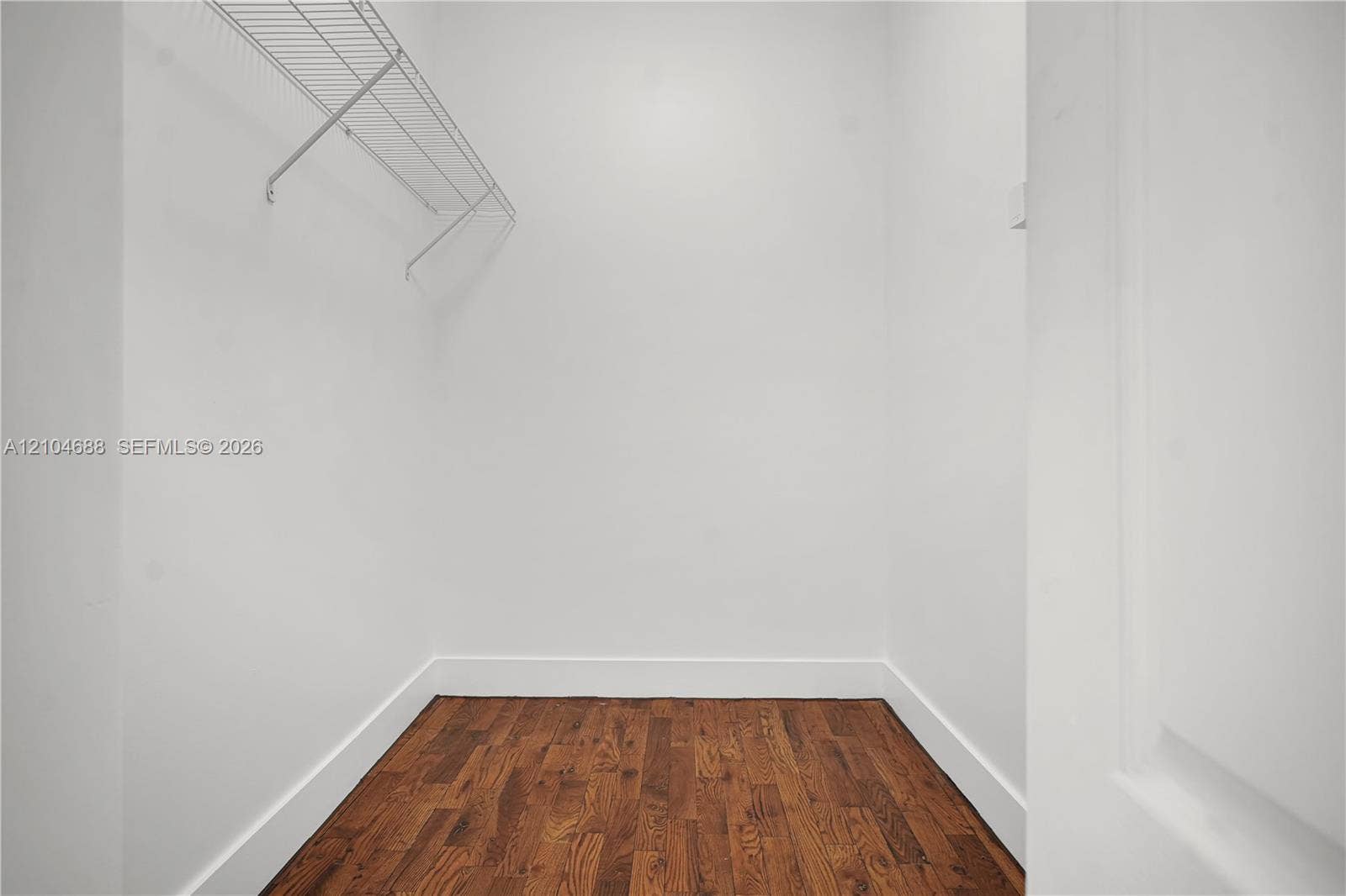 Storage area featuring wood-finish flooring and a white wire shelving system