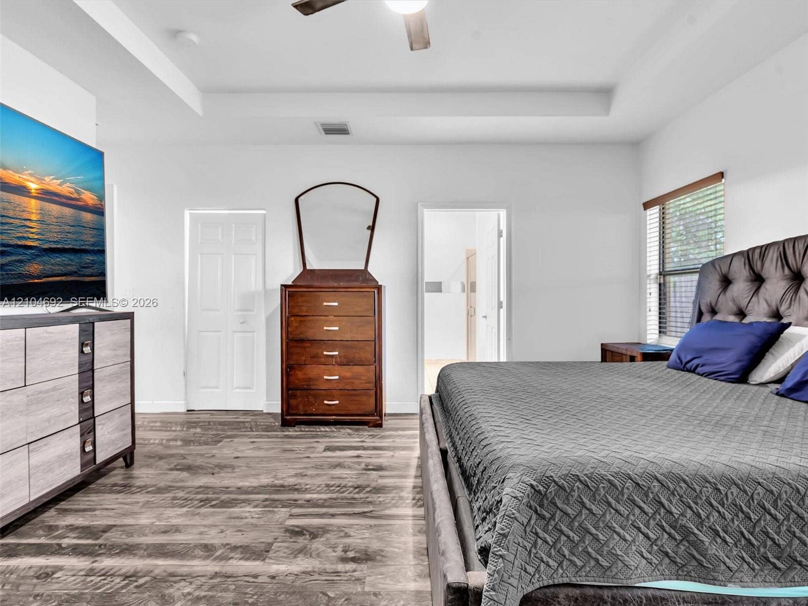 714 SE 37th Place, Homestead, FL 33033 Tray ceiling with an integrated ceiling fan, wood-finish flooring, and window blinds