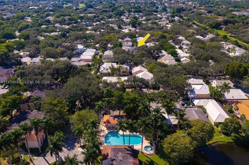9963 NW 2nd Court, Plantation, FL 33324 Aerial perspective highlighting a mature residential neighborhood featuring abundant tree canopy and a community recreation area with a swimming pool and spa
