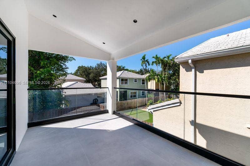 9963 NW 2nd Court, Plantation, FL 33324 Covered balcony featuring large-format tile flooring, recessed lighting, and a frameless glass railing with a matte black metal frame