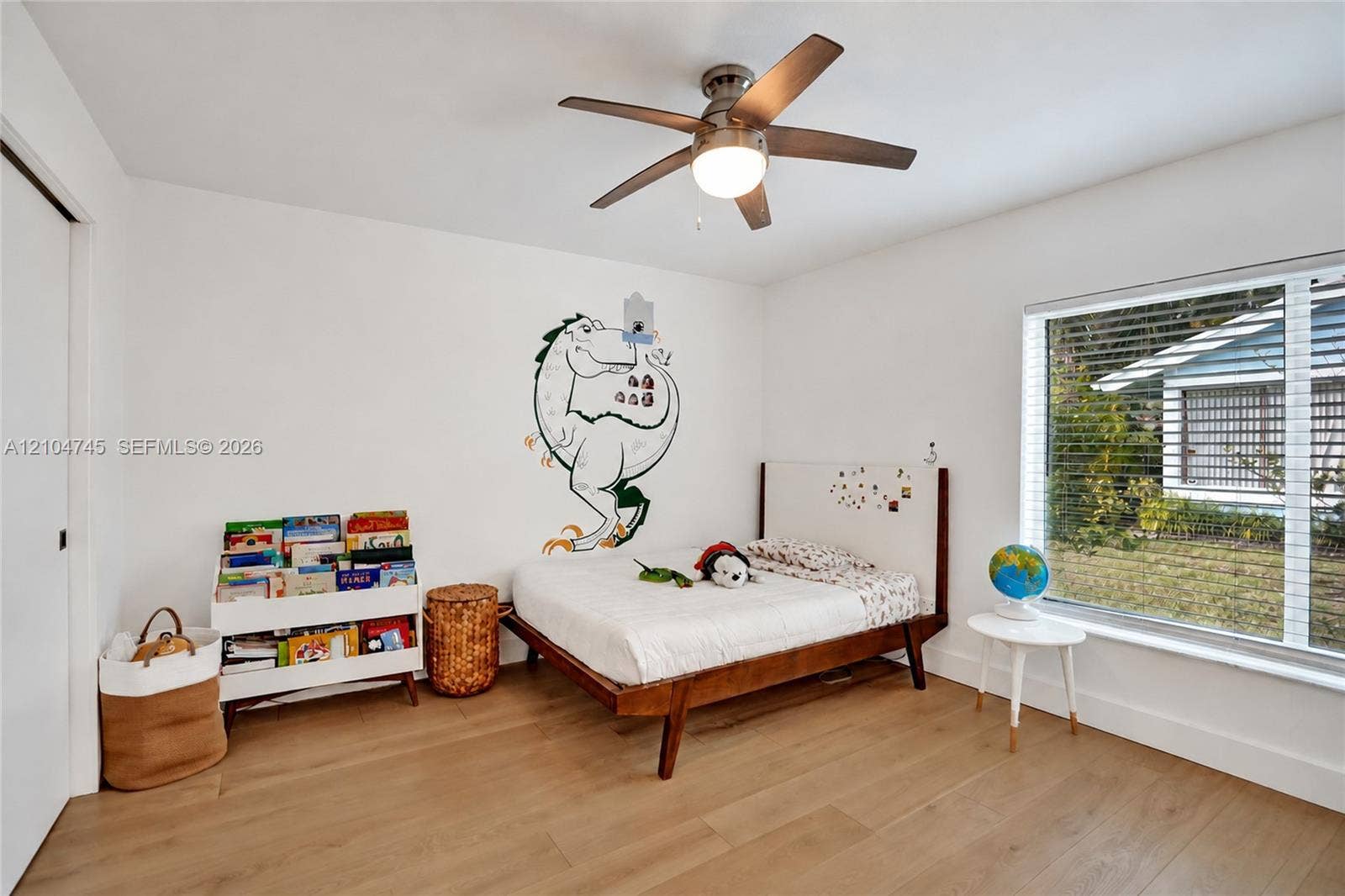 Wood-finish flooring, white walls, and a ceiling fan with integrated lighting