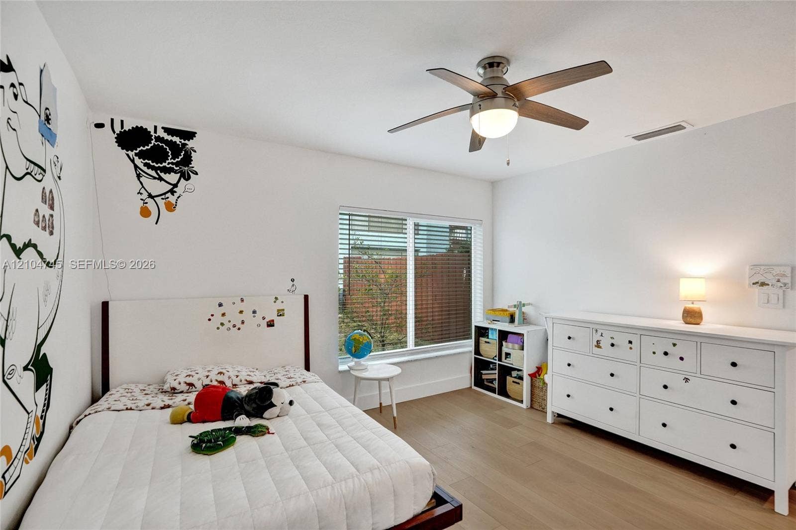 Recessed window with blinds, wood-finish flooring, and a ceiling fan with integrated lighting