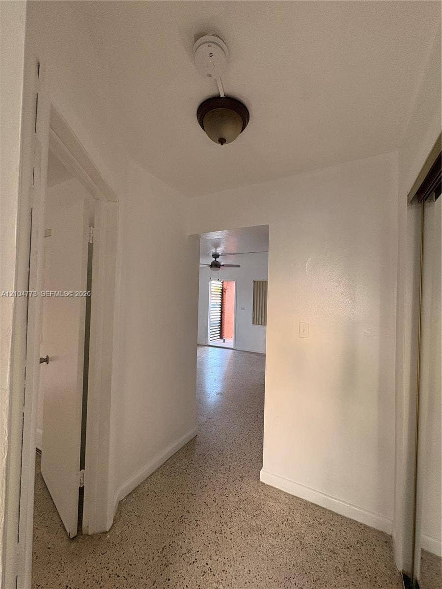 Hallway with terrazzo flooring and a flush-mount light fixture