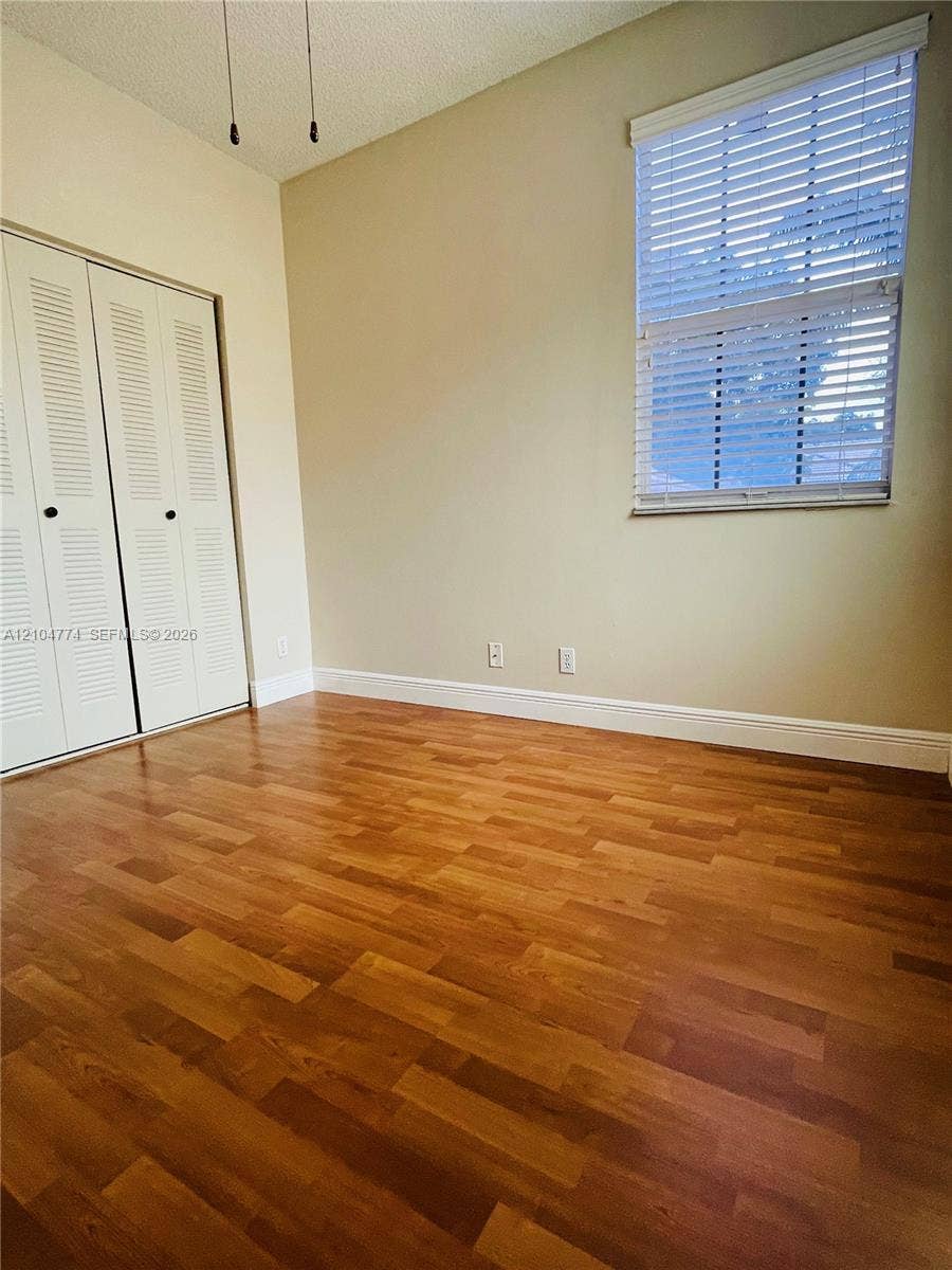 1503 Veracruz Lane, #5-14, Weston, Weston, FL 33327 Wood-finish flooring, high ceilings, dual louvered closet doors, and a window fitted with horizontal blinds