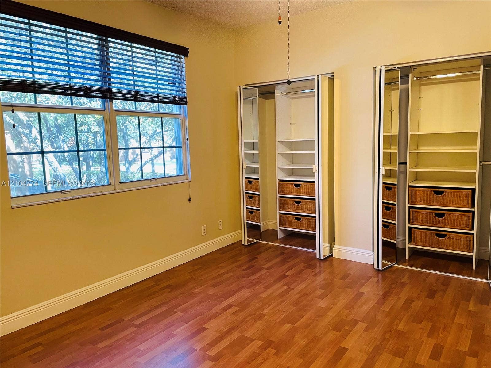 1503 Veracruz Lane, #5-14, Weston, Weston, FL 33327 Wood-finish flooring, large double window with blinds, and dual custom closet systems featuring built-in shelving and integrated drawers