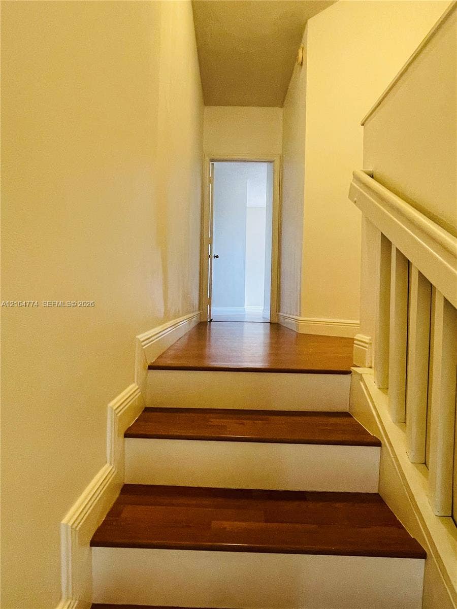 1503 Veracruz Lane, #5-14, Weston, Weston, FL 33327 Staircase featuring wood-finish treads, white risers, and a painted wooden balustrade