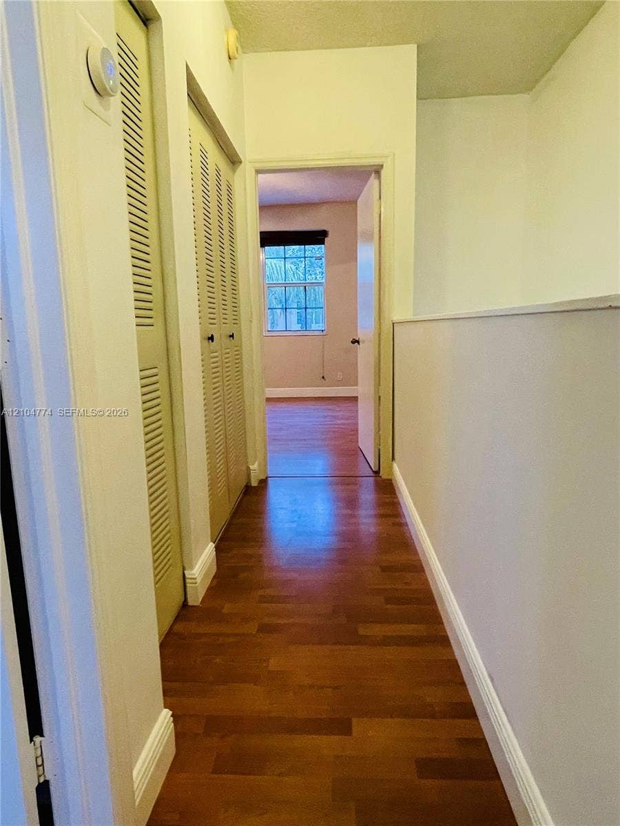 1503 Veracruz Lane, #5-14, Weston, Weston, FL 33327 Hallway featuring wood-finish flooring, louvered bi-fold closet doors, and a half-wall partition