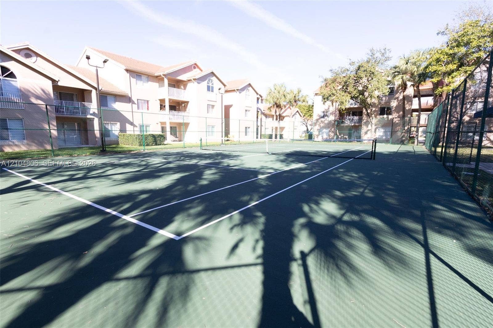 10451 SW 157th Place, #303, Miami, FL 33196 Full-size tennis court with a dark green playing surface and white boundary lines