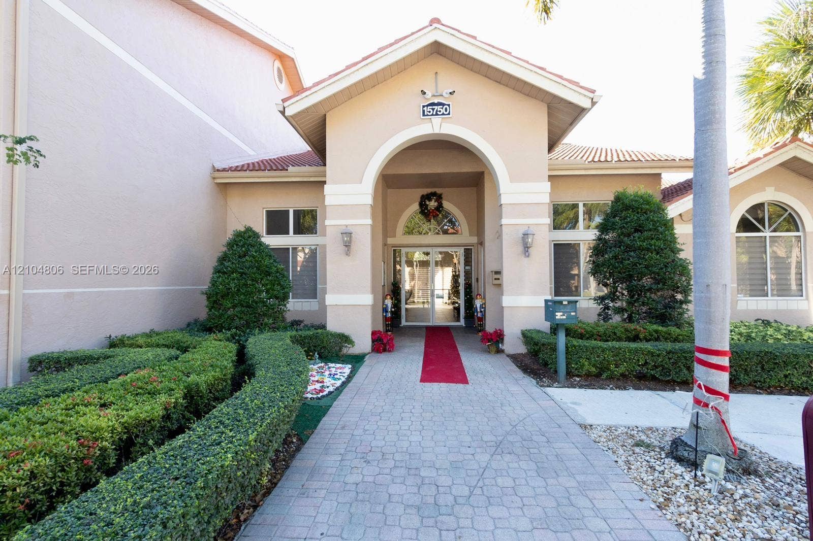 10451 SW 157th Place, #303, Miami, FL 33196 Stucco exterior with a tiled roof, arched entryway, and decorative exterior lighting