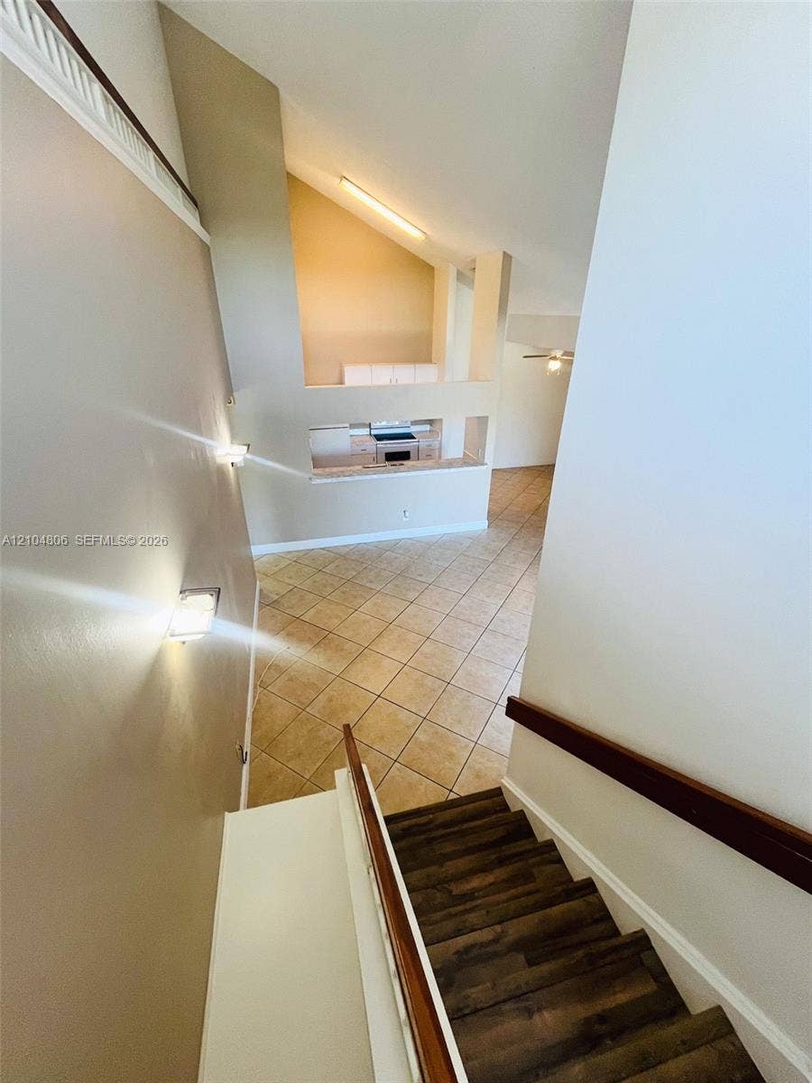 10451 SW 157th Place, #303, Miami, FL 33196 Vaulted ceilings, wood-finish stair treads, tile flooring, built-in kitchen cabinetry, and a ceiling fan