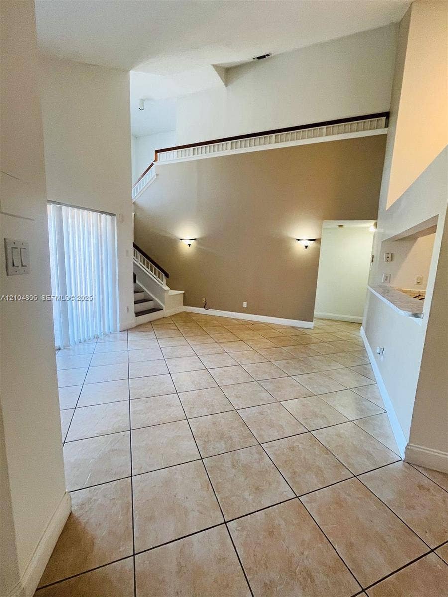 10451 SW 157th Place, #303, Miami, FL 33196 High ceilings, neutral-toned walls, tile flooring, two-story architectural elements, and recessed wall lighting