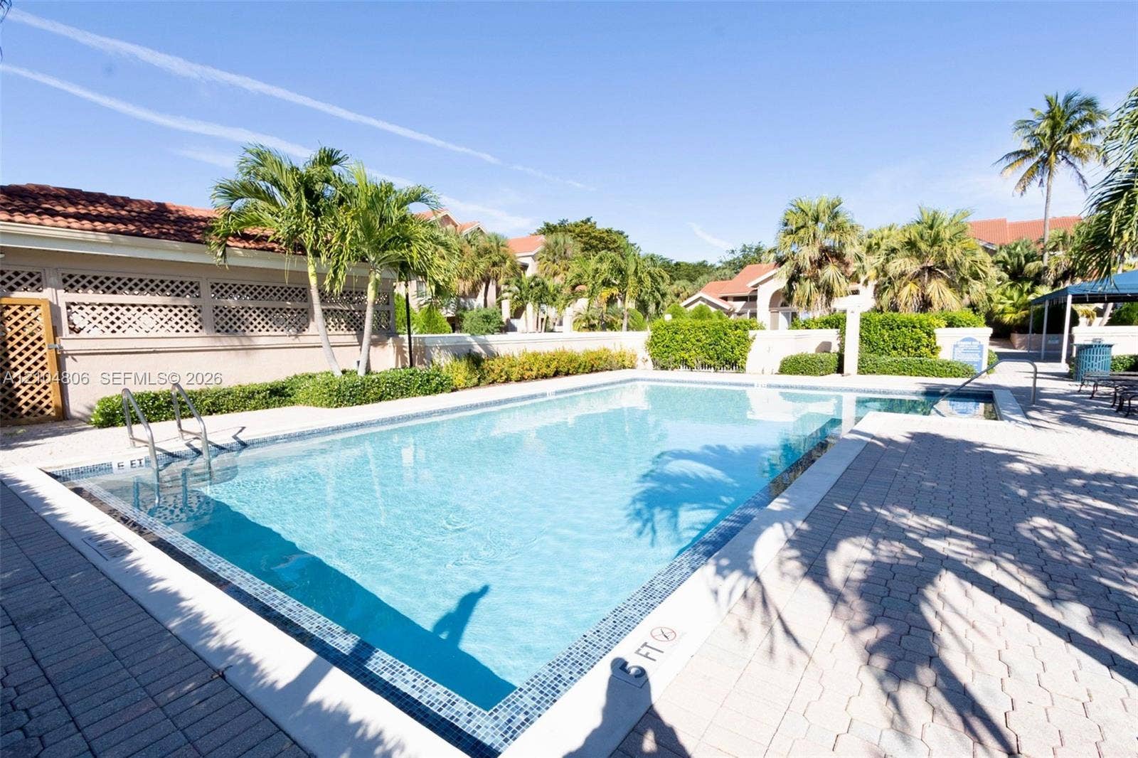 10451 SW 157th Place, #303, Miami, FL 33196 Rectangular swimming pool with mosaic tile accents, integrated spa, and surrounding paver decking