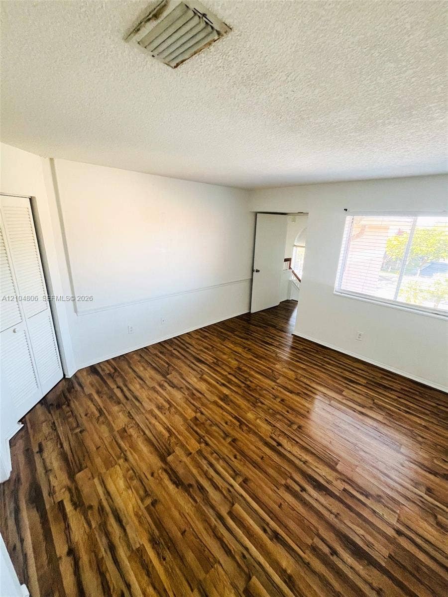 10451 SW 157th Place, #303, Miami, FL 33196 Wood-finish flooring throughout, white walls, and a window providing natural light
