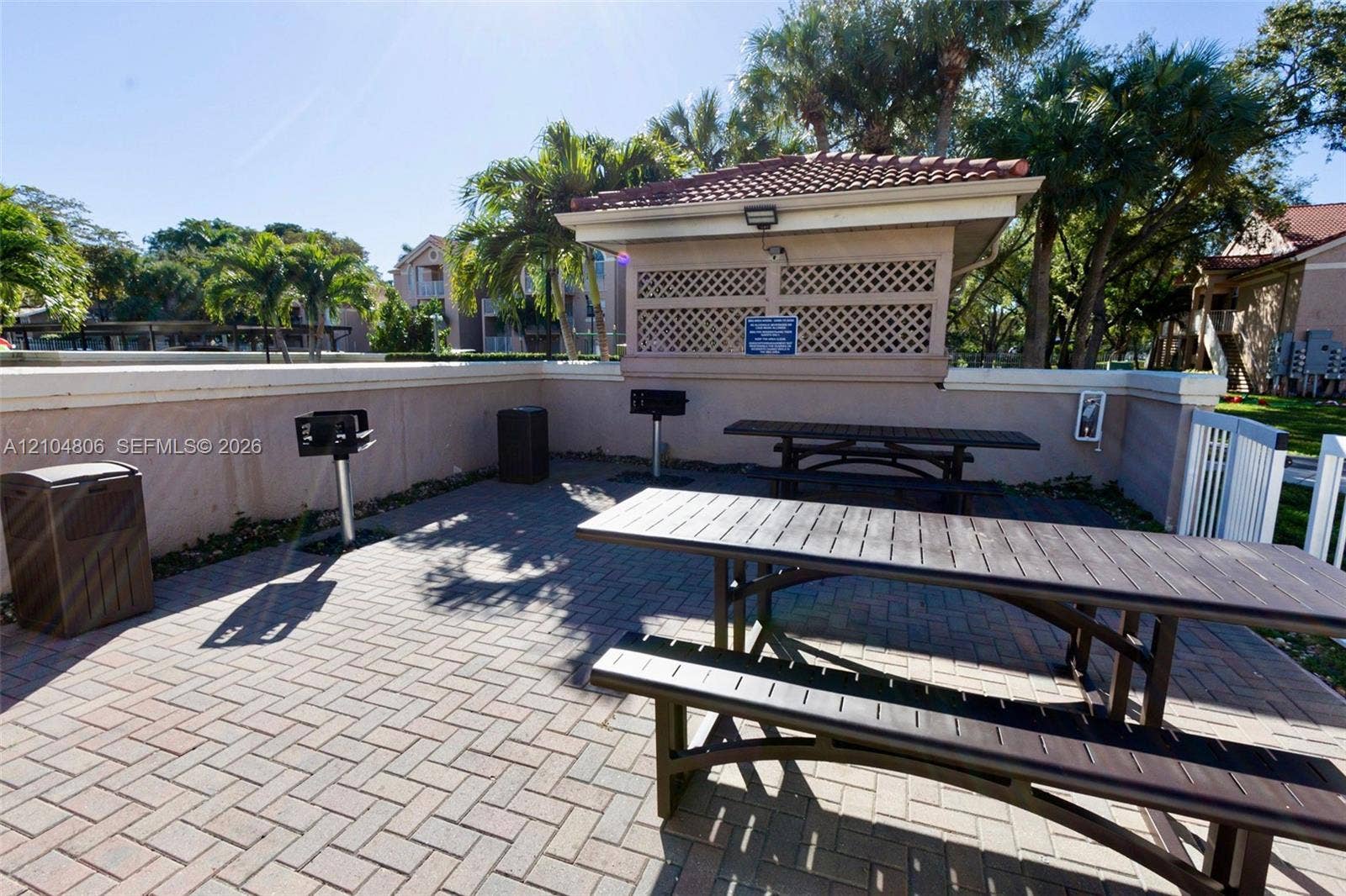 10451 SW 157th Place, #303, Miami, FL 33196 Paver patio featuring multiple picnic tables and a covered BBQ area