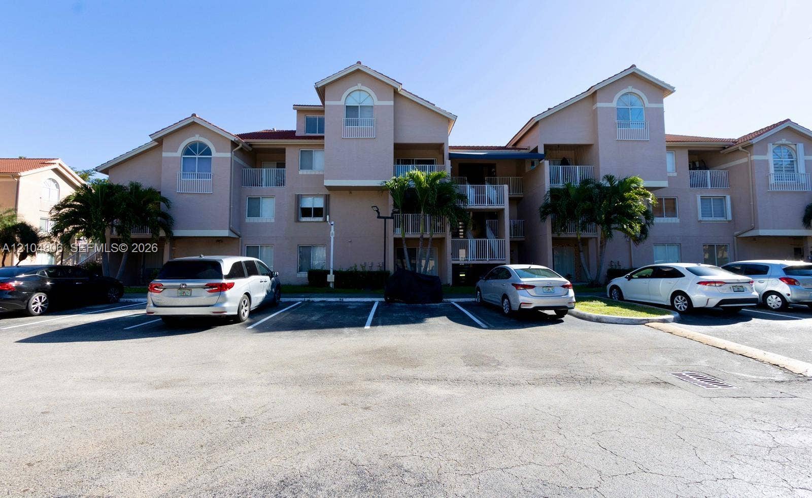 10451 SW 157th Place, #303, Miami, FL 33196 Multi-story building featuring balconies, arch-top windows, and a tile roof