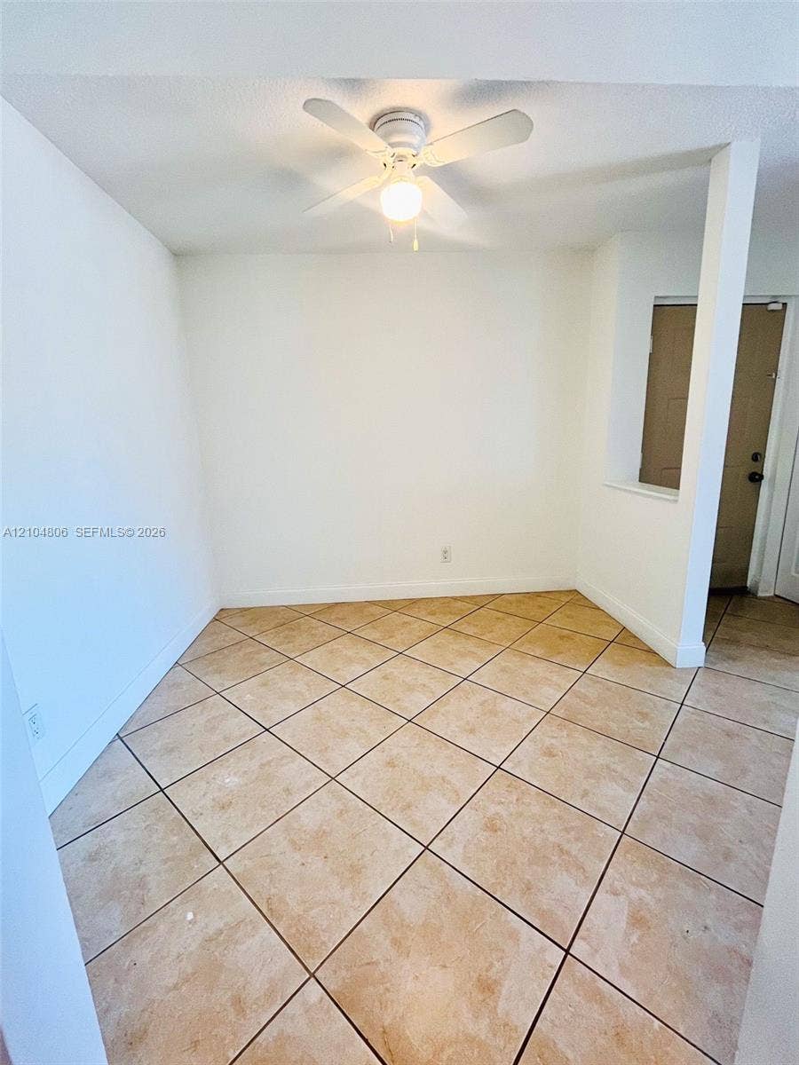 10451 SW 157th Place, #303, Miami, FL 33196 Light-toned tile flooring, white walls, and a ceiling fan with integrated lighting