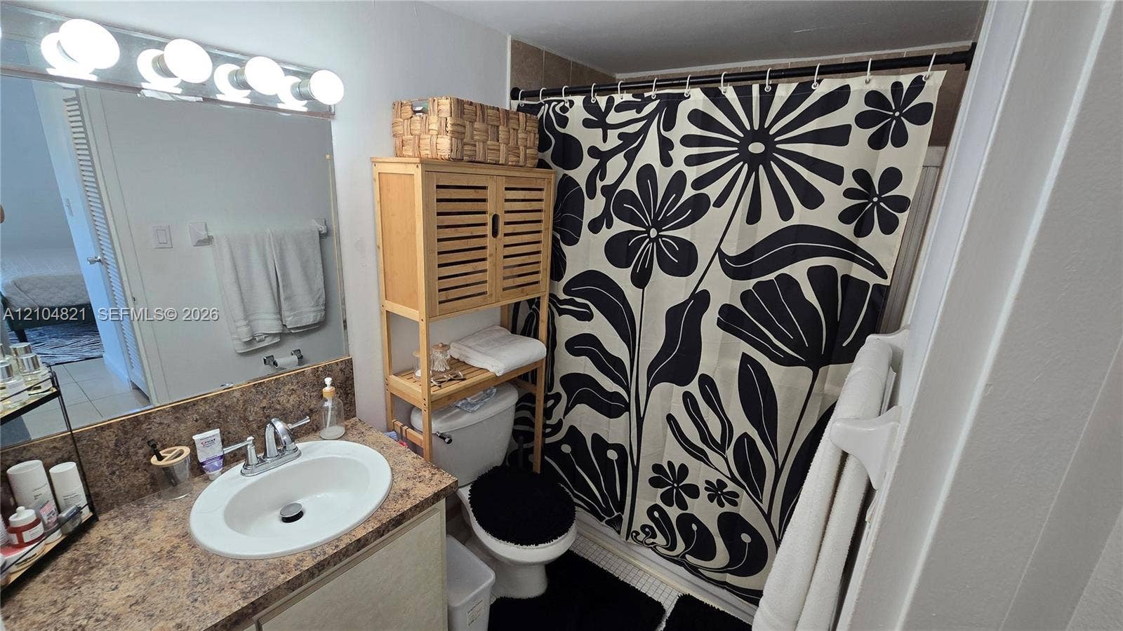 Vanity with integrated sink, chrome faucet, and expansive wall mirror