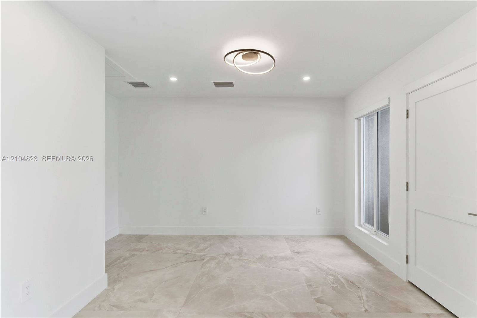 291 E Shore Drive E, Miami, FL 33133 Neutral-toned oversized tile flooring, modern circular LED flush-mount lighting, recessed ceiling lights, and a white two-panel interior door