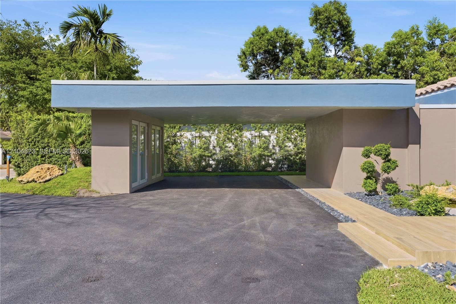 291 E Shore Drive E, Miami, FL 33133 Covered entryway with asphalt driveway and modern landscaping