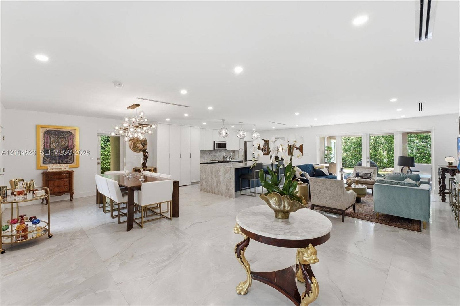 291 E Shore Drive E, Miami, FL 33133 Expansive open-concept space with large format tile flooring, recessed lighting, and a contemporary chandelier