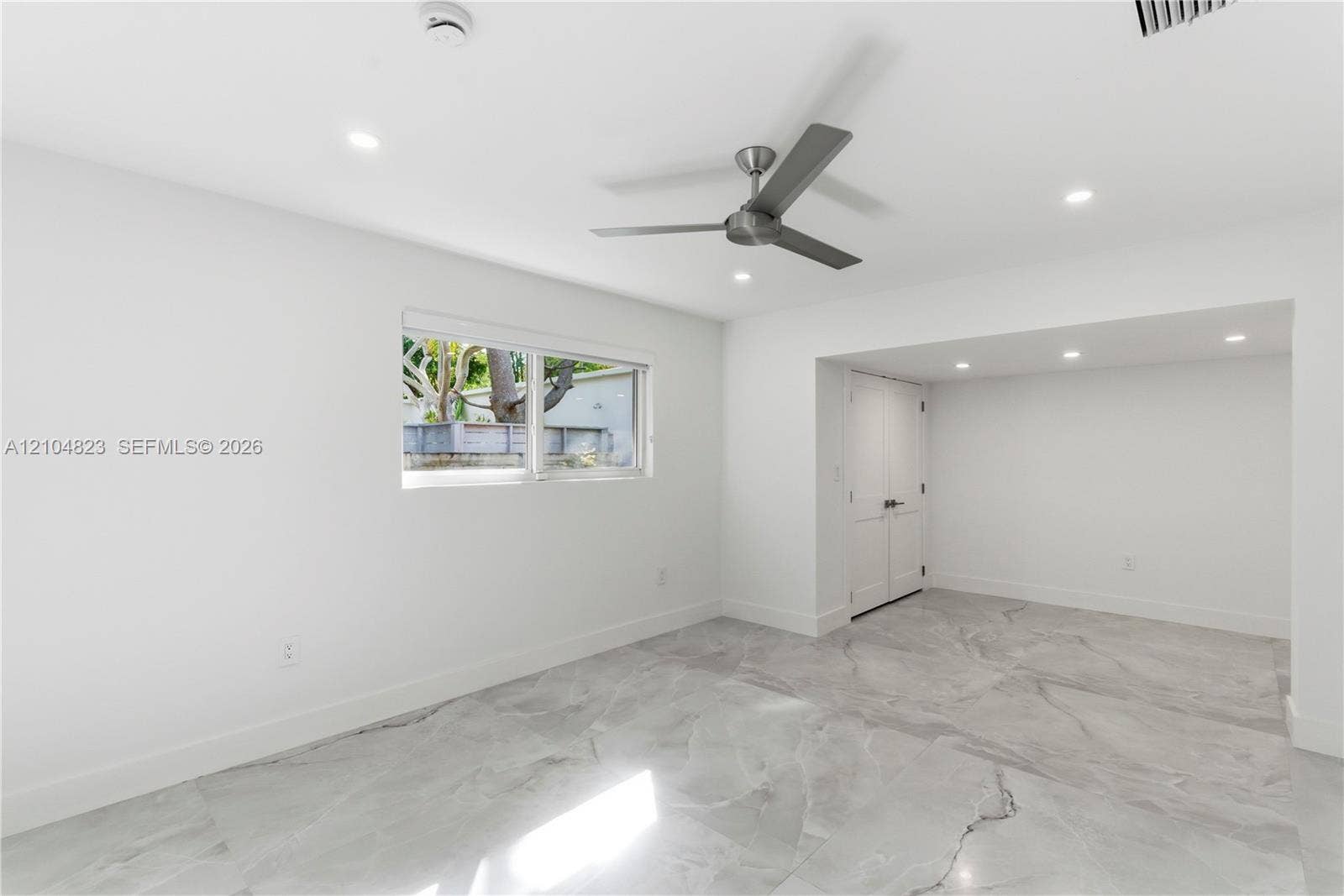 291 E Shore Drive E, Miami, FL 33133 Interior space featuring large-format tile flooring, recessed ceiling lighting, a contemporary brushed-metal ceiling fan, and double-door closet cabinetry