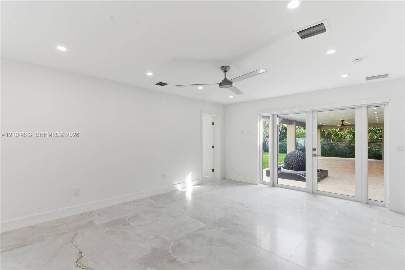 291 E Shore Drive E, Miami, FL 33133 Large-format tiled flooring, recessed ceiling lighting, three-blade ceiling fan, and multi-panel glass door system