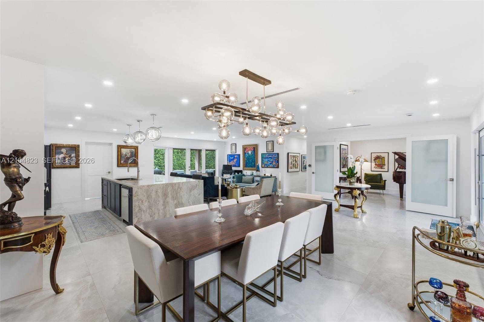 291 E Shore Drive E, Miami, FL 33133 Spacious interior featuring a large kitchen island with a stone countertop, an open-concept layout, recessed lighting, and a modern chandelier