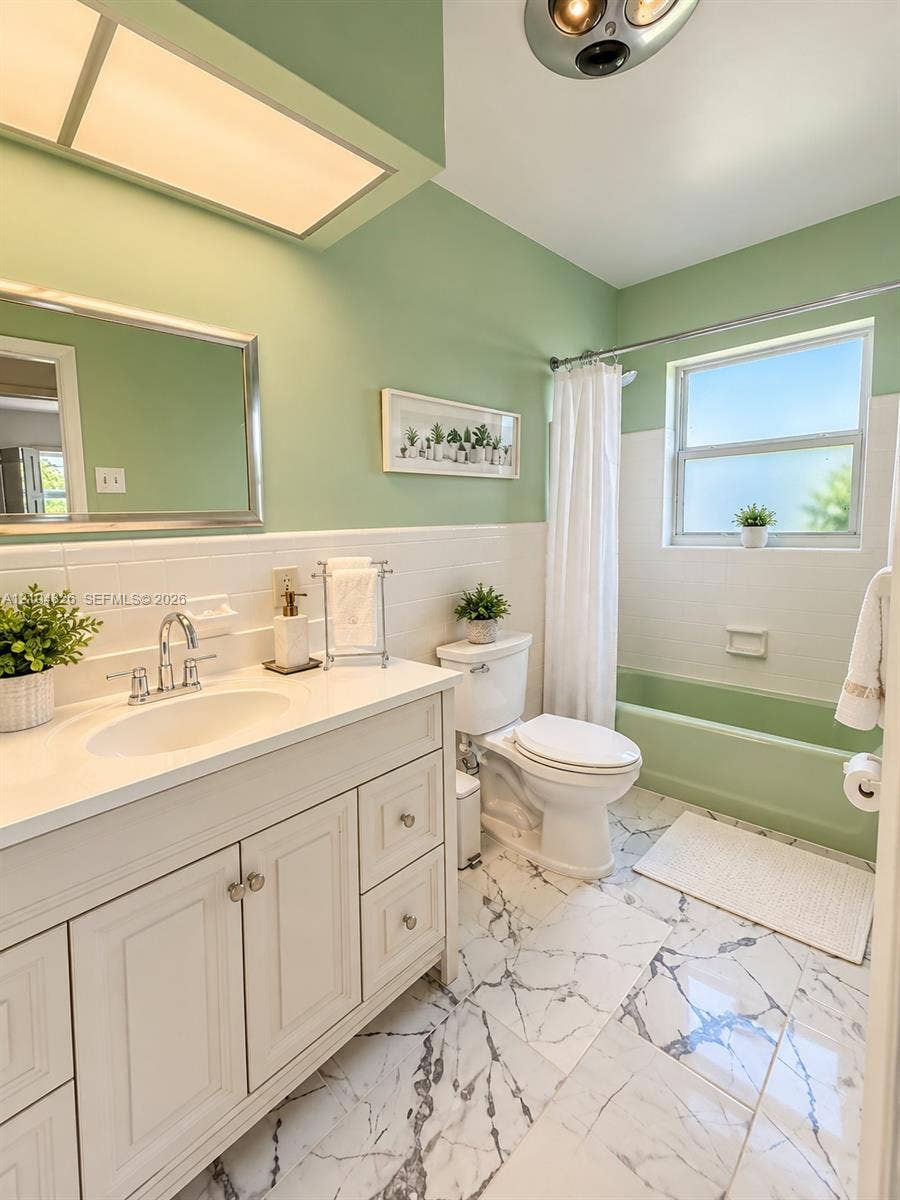 White vanity with integrated sink, chrome faucet, and storage cabinetry