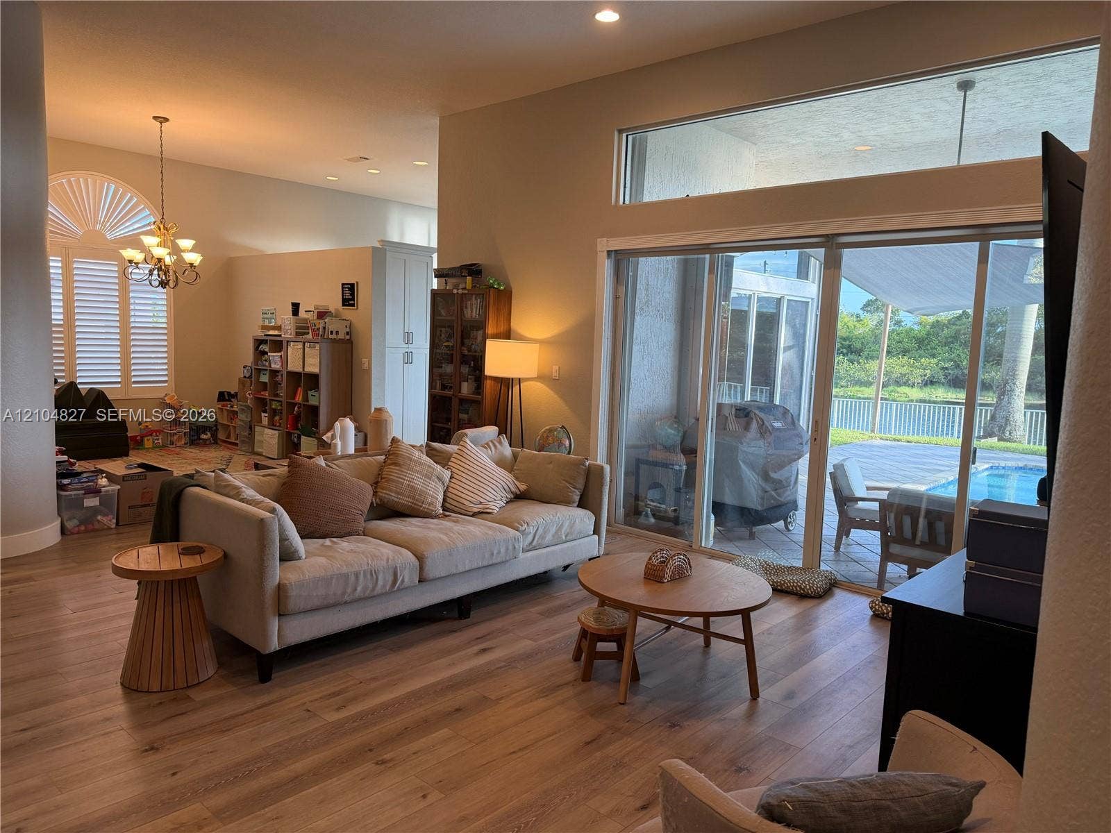 Spacious interior with wood-finish flooring, high ceilings, and a decorative chandelier