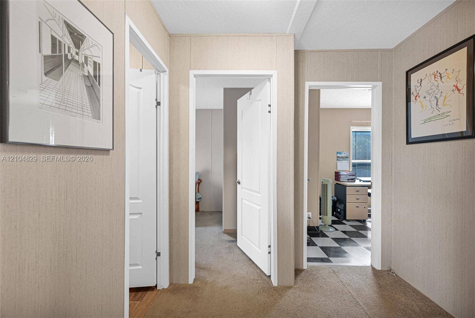 1880 SW 83rd Terrace, Davie, FL 33324 Hallway featuring textured wall paneling and interior doors with molded detailing