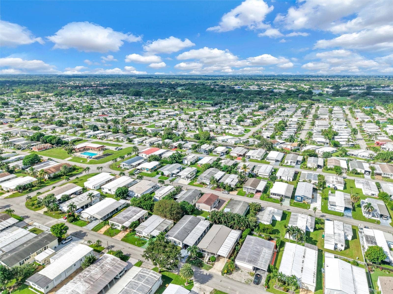 1880 SW 83rd Terrace, Davie, FL 33324 Aerial perspective of the residential community featuring paved street networks, established landscaping, and a central swimming pool facility