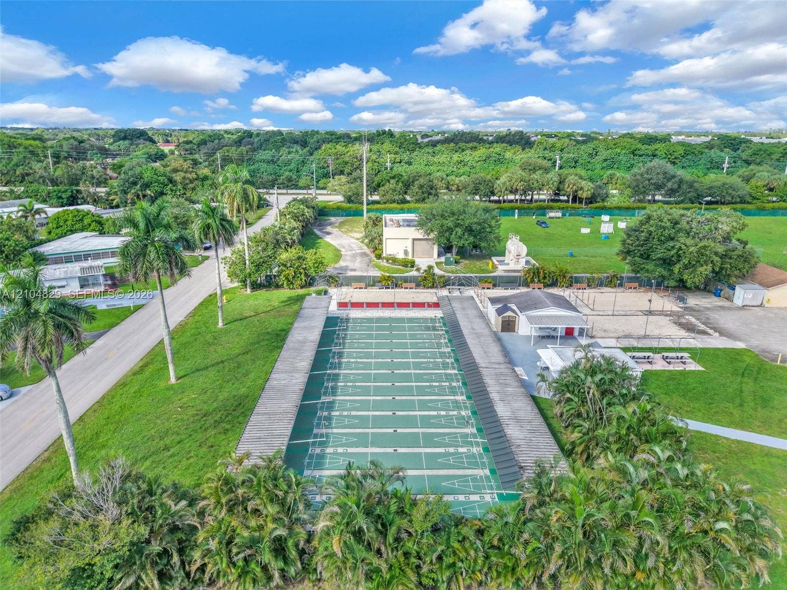 1880 SW 83rd Terrace, Davie, FL 33324 Outdoor recreational area featuring multi-lane shuffleboard courts, a covered pavilion, and integrated landscaping