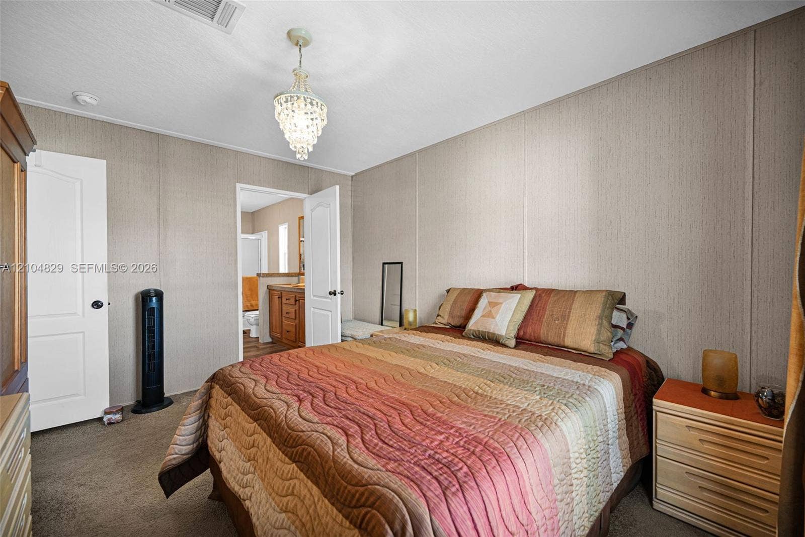1880 SW 83rd Terrace, Davie, FL 33324 Neutral wall paneling, carpeting, white interior doors with brushed hardware, and a crystal-style chandelier fixture