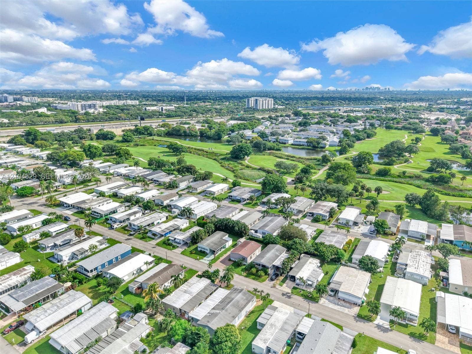 1880 SW 83rd Terrace, Davie, FL 33324 Aerial perspective featuring an established residential community with mature landscaping, green spaces, and integrated water features