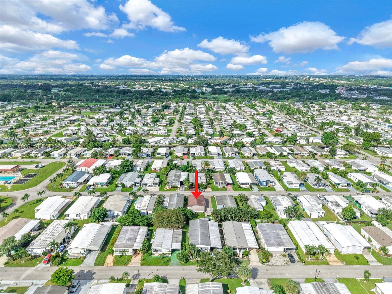 1880 SW 83rd Terrace, Davie, FL 33324 Aerial perspective of a detached residence featuring a gable roof, integrated driveway, and mature landscaping within a planned community setting