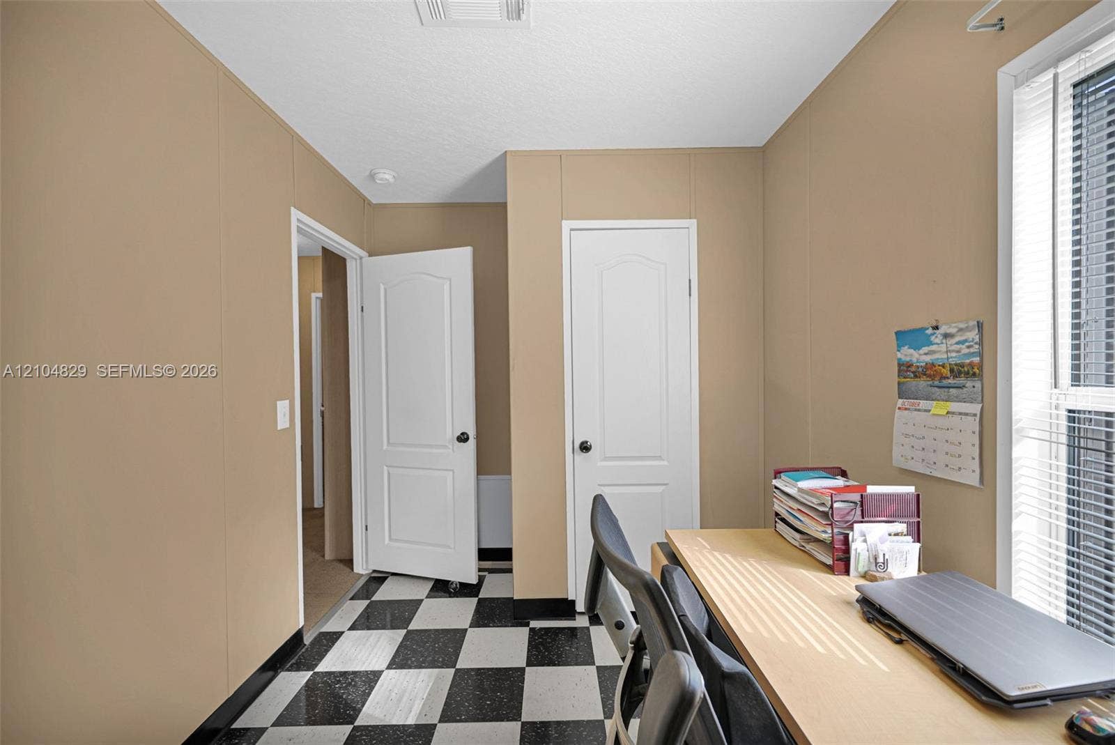 1880 SW 83rd Terrace, Davie, FL 33324 Interior room featuring checkered vinyl flooring, two white panel doors, and a window with horizontal blinds