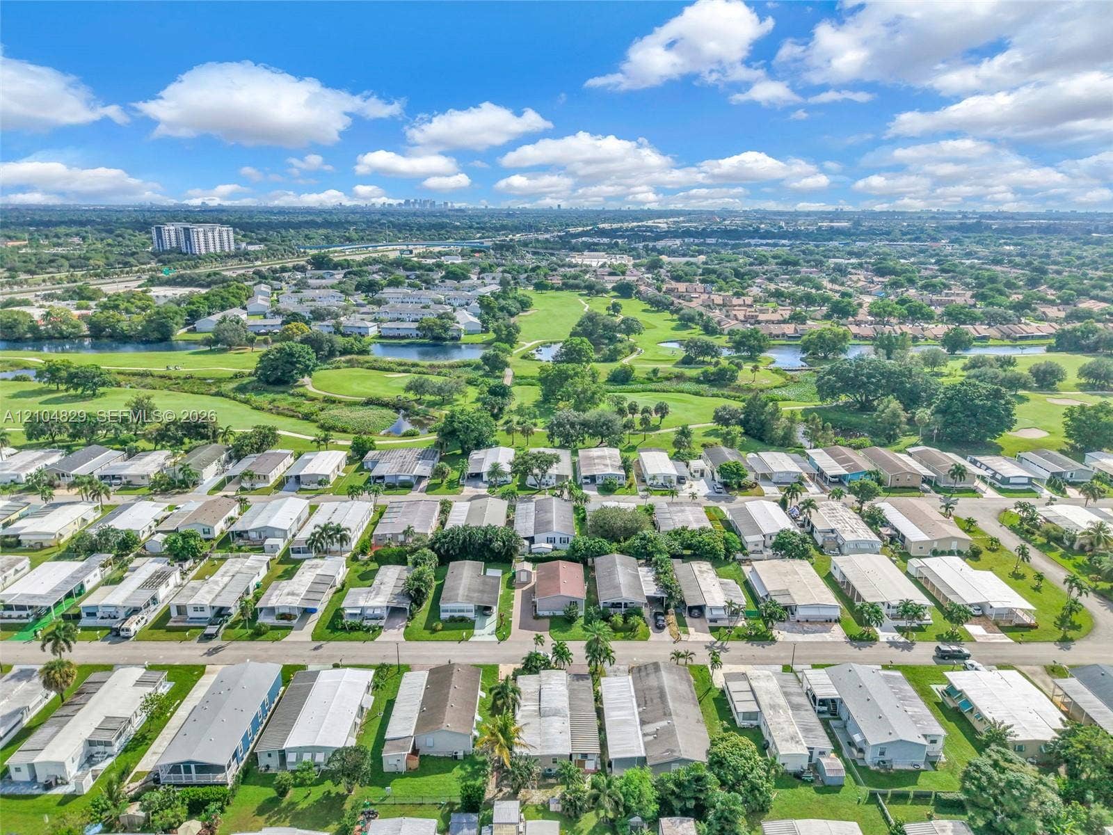 1880 SW 83rd Terrace, Davie, FL 33324 Aerial perspective featuring manicured grounds, expansive fairways, and multiple water features