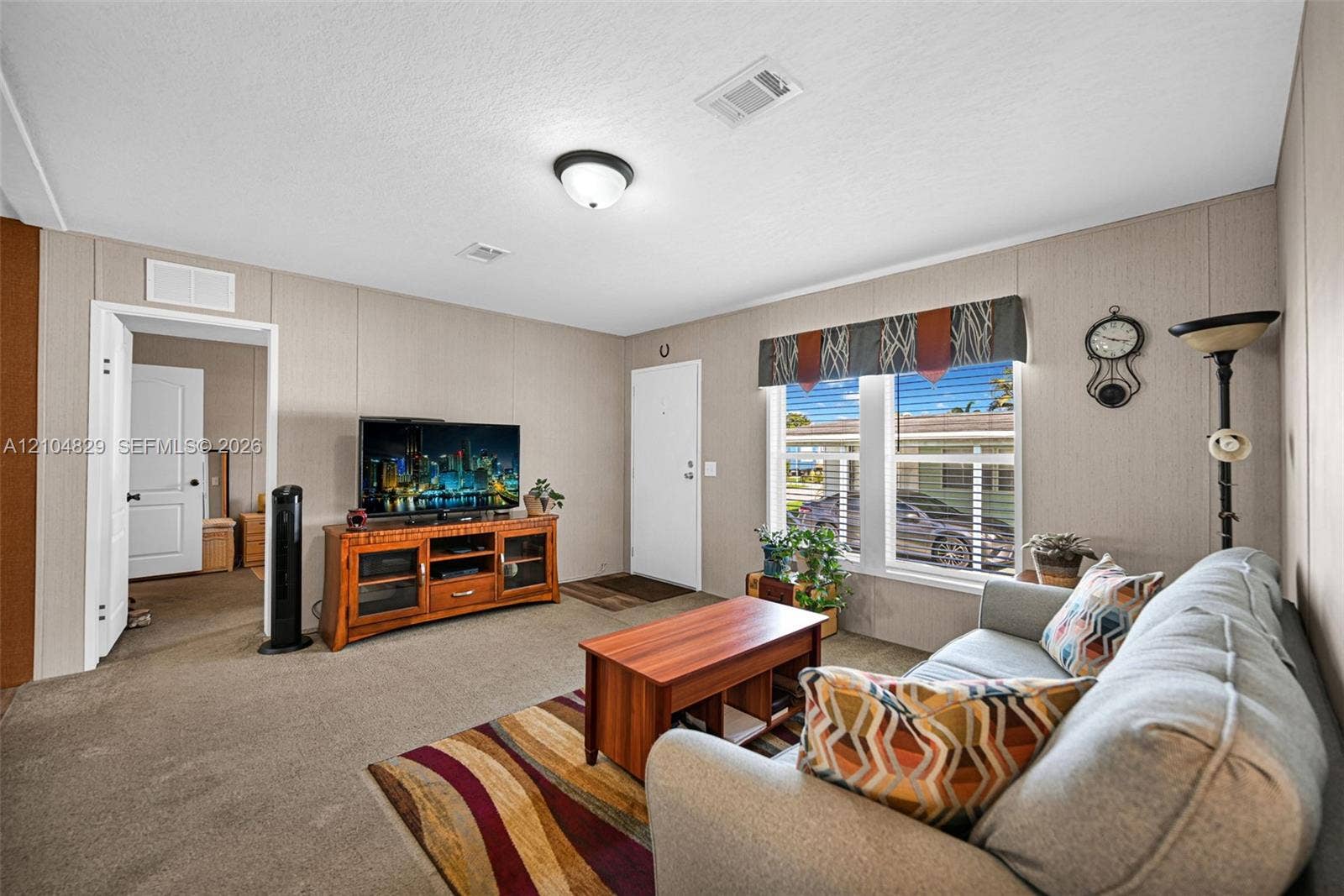1880 SW 83rd Terrace, Davie, FL 33324 Neutral-toned wall paneling, wall-to-wall carpeting, dual-pane windows, and a flush-mount ceiling light fixture