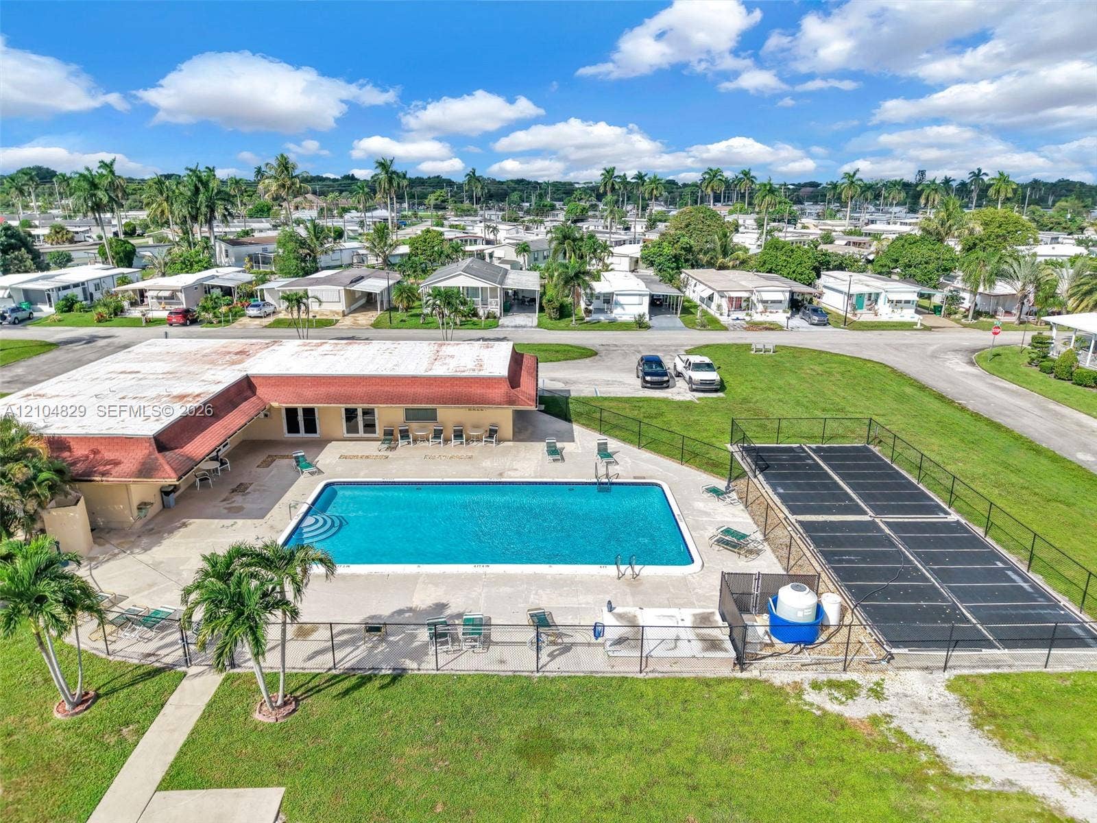 1880 SW 83rd Terrace, Davie, FL 33324 Outdoor recreation area featuring a swimming pool, concrete pool deck, fenced perimeter, and solar pool heating panels
