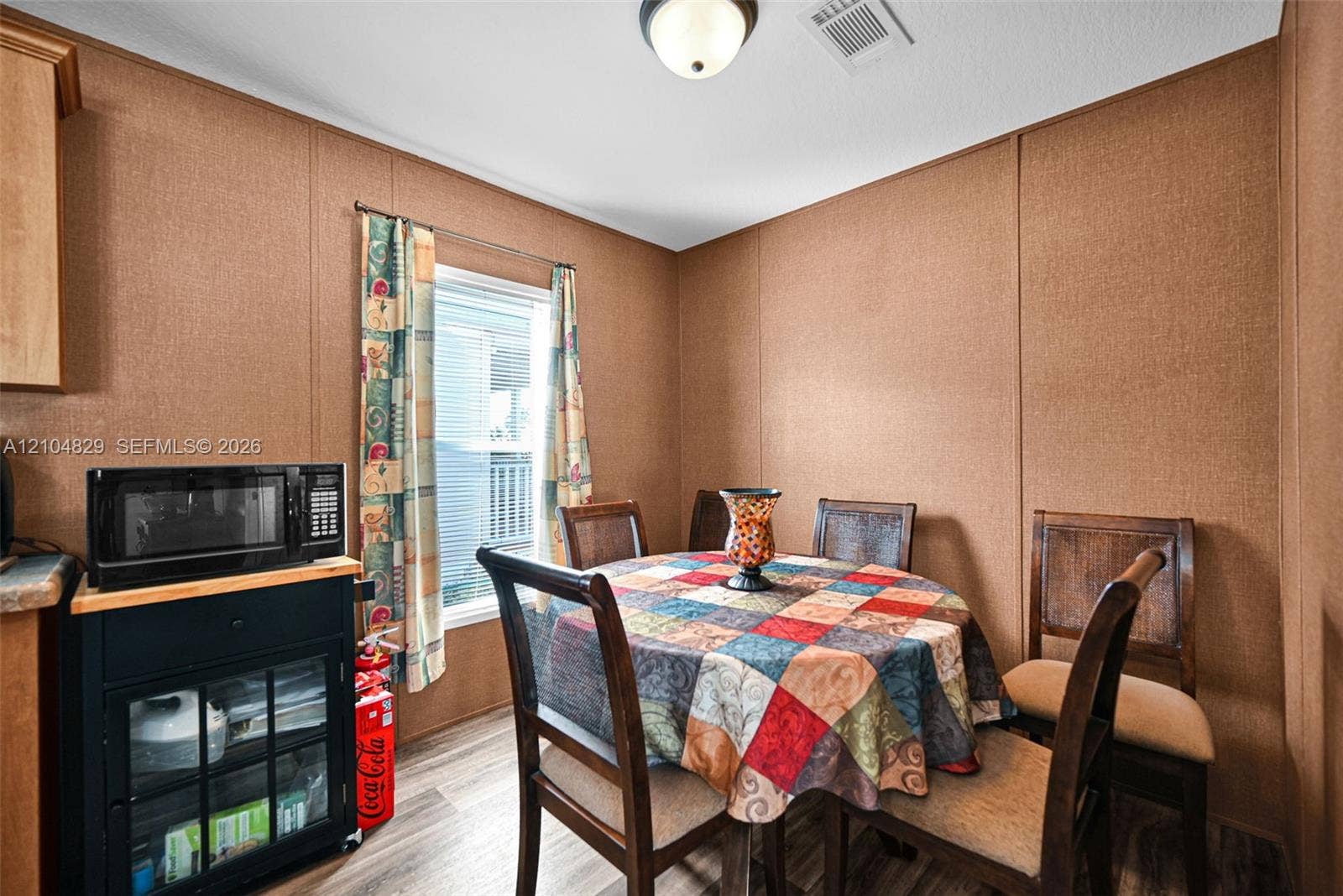 1880 SW 83rd Terrace, Davie, FL 33324 Textured wall paneling, wood-finish flooring, and a single-pane window with natural lighting