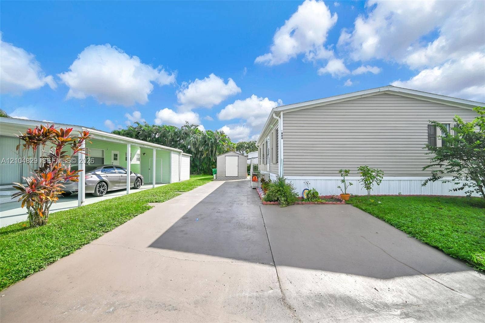 1880 SW 83rd Terrace, Davie, FL 33324 Horizontal siding exterior with a concrete driveway, covered parking area, and detached storage shed