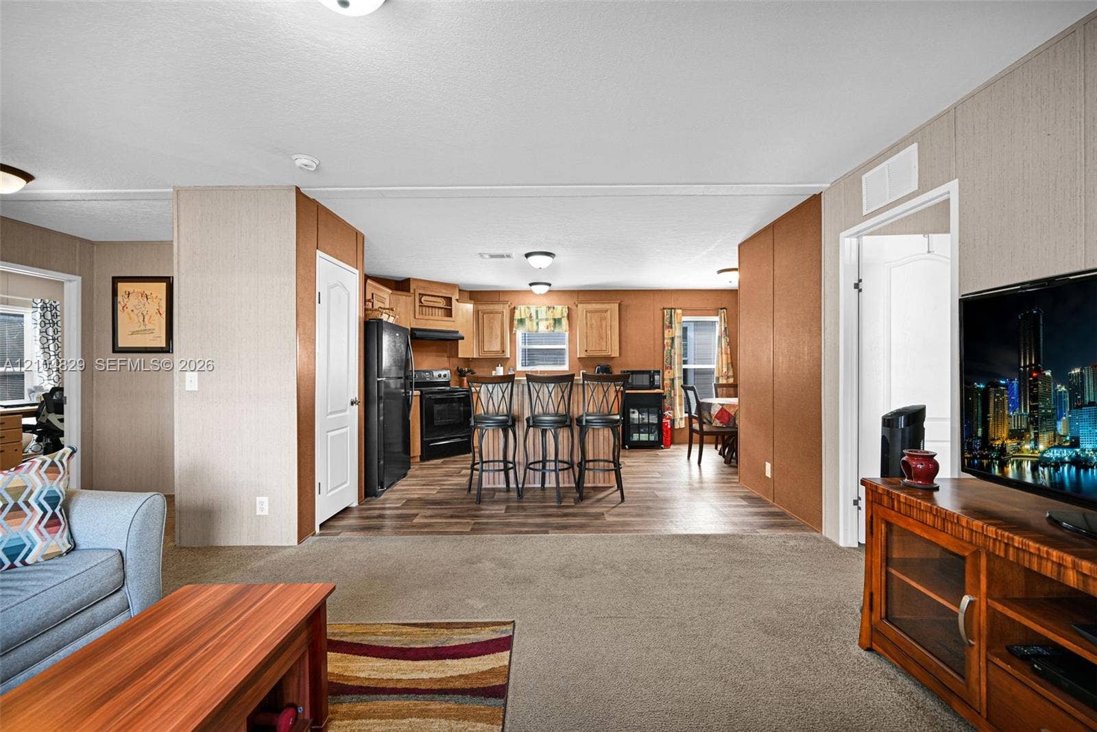 1880 SW 83rd Terrace, Davie, FL 33324 Kitchen featuring wood cabinetry, a center island with bar seating, and plank-style flooring