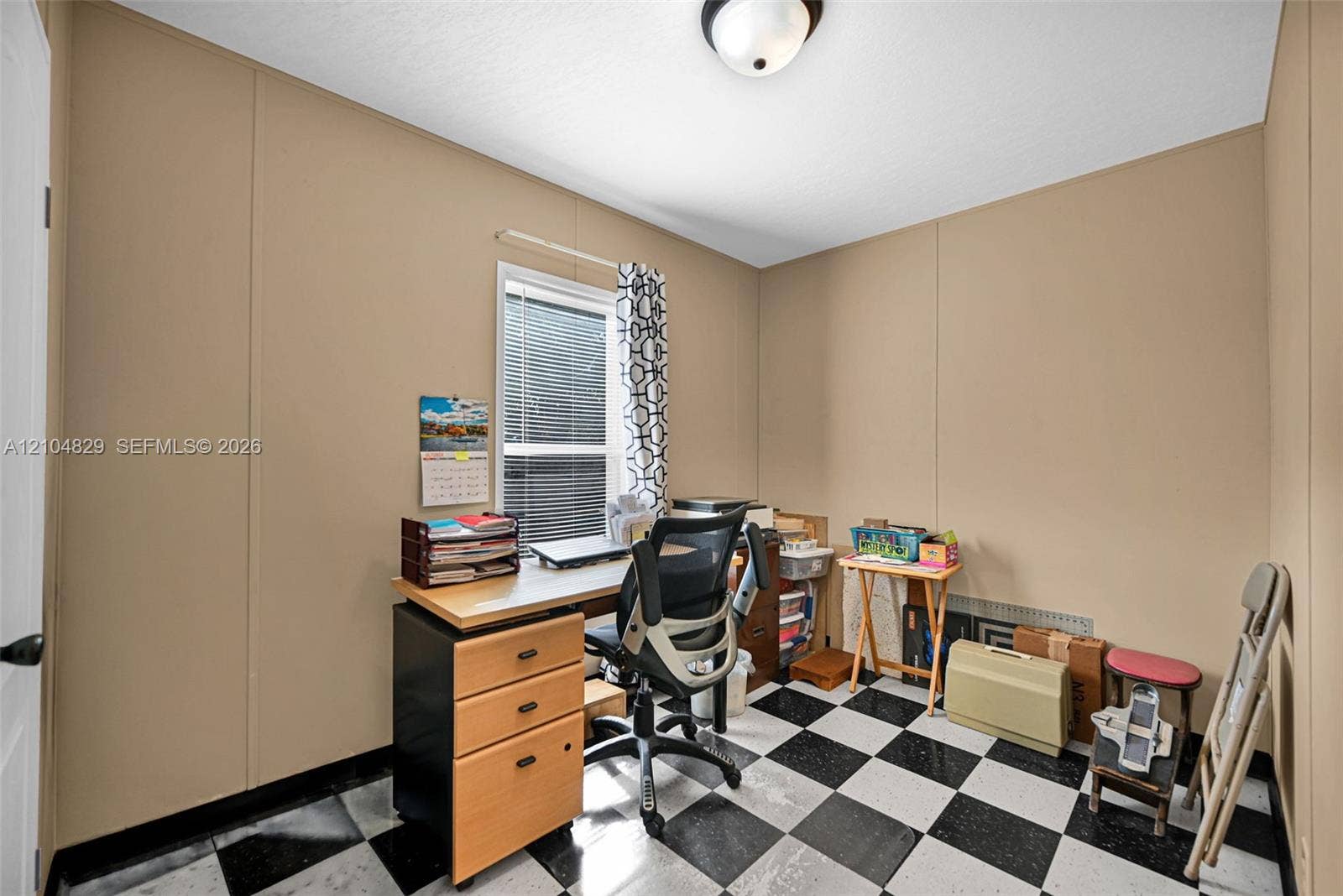 1880 SW 83rd Terrace, Davie, FL 33324 Interior space featuring checkered tile flooring, neutral wall paneling, and a flush-mount ceiling light fixture